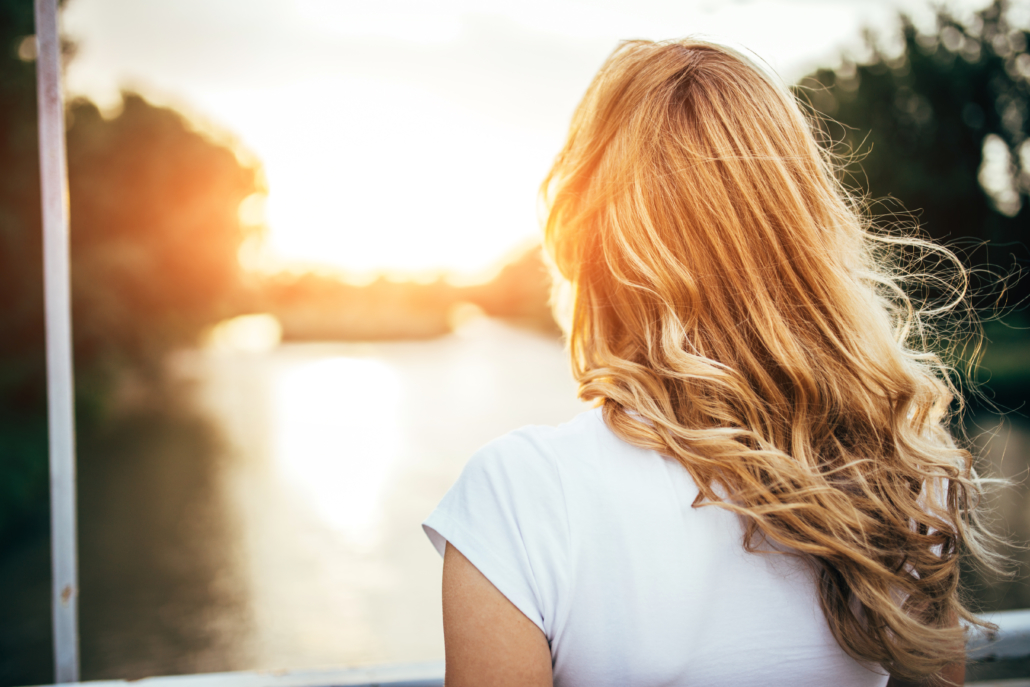 Entspannung im Alltag: Frau mit langen blonden Haaren sieht auf's Wasser